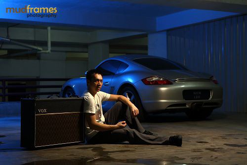 Test shot of Nick Lee in front of a Porsche at a basement car park
