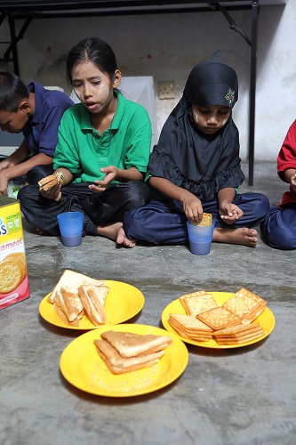 Myanmar children refugees having lunch at PBCC Learning Centre in Selayang