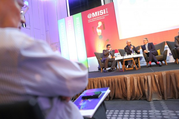 A participant listening to a panel of doctors discussing during MISI 2014